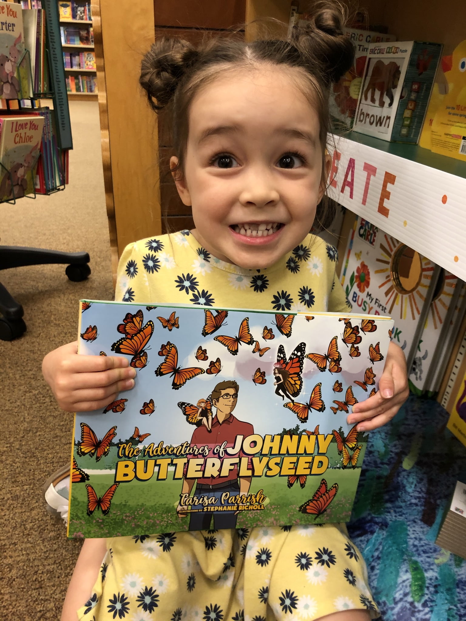 Cute Girl holding 'The Adventures of Johnny Butterflyseed' book.